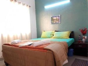 瓦加托JMD VILLA的卧室内的一张床铺,卧室内有蓝色的墙壁