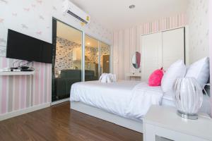 慕斯Courtyard khaoyai by JP的卧室配有白色的粉色和白色条纹床