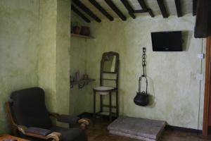 希罗内利亚卡尔西斯特勒度假屋的客厅配有椅子、电视和凳子