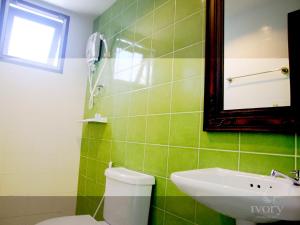 皮皮岛皮皮岛象牙酒店的绿色瓷砖浴室设有卫生间和水槽