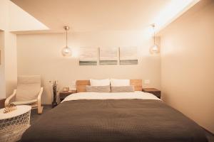 东京Monoka Hotel Ginza的一间卧室配有一张大床和一把椅子