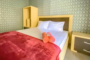 BetekTini's Guest House Malang Mitra RedDoorz的一间卧室配有一张床,上面有两条毛巾