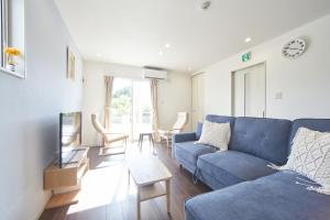 濑底villa PILINA的客厅配有蓝色的沙发和椅子