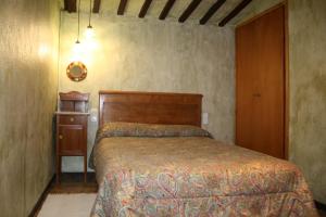希罗内利亚卡尔西斯特勒度假屋的一间卧室配有一张床和一个木制床头板