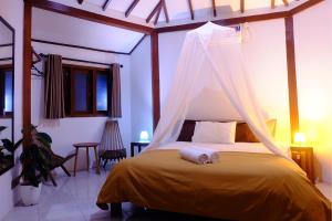 卡里蒙贾瓦卡里姆加瓦阿玉酒店的一间卧室配有一张带蚊帐的床