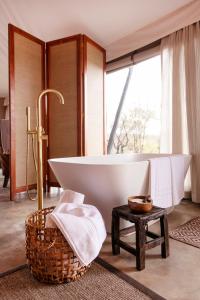 提姆巴瓦提禁猎区Thabamati Luxury Tented Camp的带浴缸的浴室和大窗户