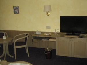 安斯巴赫Hotel-Gasthof Rangau的客房设有书桌、电视和桌椅