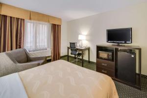 苏福尔斯Quality Inn & Suites South的配有一张床和一台平面电视的酒店客房