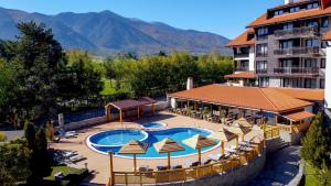 班斯科The Balkan Jewel Resort, Trademark Collection by Wyndham的酒店设有带椅子和遮阳伞的游泳池
