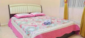 加央Cahaya Kasih Homestay的一张带粉色和白色毯子的床和鞋
