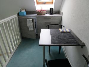文斯托夫Bed & Breakfast Wunstorf的带冰箱的小厨房配有桌椅