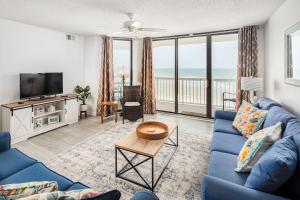 富丽海滩214 COV - Go Fly a Kite - Oceanfront Condo - 2 Pools的客厅配有蓝色的沙发和电视