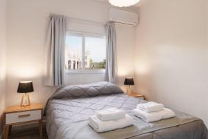 科洛尼亚-德尔萨克拉门托Taurinas的一间卧室配有一张床,上面有两条毛巾