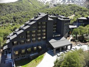 奇廉内瓦达斯Hotel Termas Chillán的享有建筑的空中景观,以群山为背景