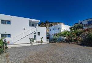 阿彻奇洛斯Mediterraneo Apartments的山坡上拥有白色墙壁和楼梯的房子