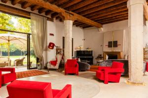 洛尼戈La Barchessa di Villa Pisani的客厅配有红色椅子和壁炉
