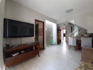 阿拉亚尔-杜卡布Serra Mar Suítes,Lofts, e casas à 300 metros das praias的客厅设有壁挂式平面电视。