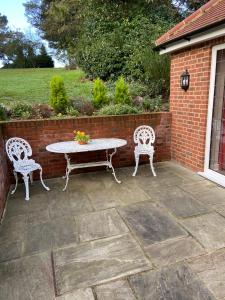 伊普斯威奇The Garden Room的庭院设有桌子、两把椅子和砖墙