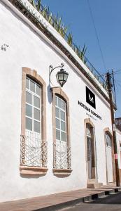 莫雷利亚M Hoteles Concepto的白色的建筑,有窗户和街道标志