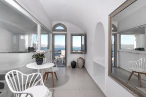 伊亚卡尔德拉尊贵别墅酒店的白色的客房配有镜子和桌椅