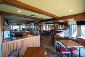 肯纳威克三叶草岛屿旅馆的一间带桌椅的餐厅和一间酒吧