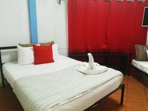 曼努埃尔安东尼奥Hotel Cafe Del Mar, En Valle Pura Vida的客房配有两张带红白色枕头的床。