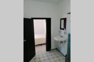 巴卡拉尔Maruchita's room的一间带水槽的浴室和一扇通往卧室的门