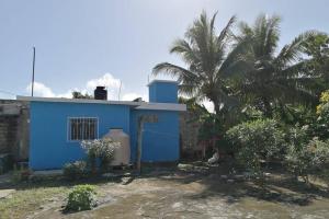 巴卡拉尔Maruchita's room的前面有棕榈树的蓝色房子