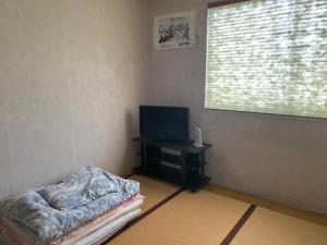 西条市Oyado Sukeya的客厅配有电视和一张桌子及一张床