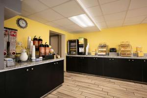 克利尔沃特Days Inn by Wyndham Clearwater/Central的厨房配有黑色橱柜和黄色的墙壁