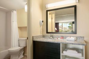 克利尔沃特Days Inn by Wyndham Clearwater/Central的一间带水槽、卫生间和镜子的浴室