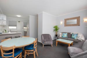 阿德莱德格莱内尔格绿洲公寓的客厅配有桌椅和沙发
