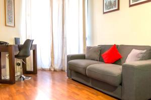 圣地亚哥Departamentos Pontoni (Bellas Artes)的客厅配有带红色枕头的灰色沙发