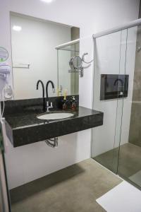瓦尔任博尼塔POUSADA JURERE DA CANASTRA的一间带水槽和玻璃淋浴的浴室
