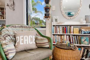 怀普Waipu Cove Palm Cottage - Waipu Cove Holiday Home的一间带椅子、桌子和镜子的房间