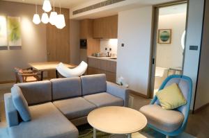 琼海琼海官塘假日度假酒店（尊享无限次温泉体验）的客厅配有沙发和桌椅