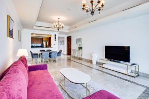 迪拜South & North Residence Palm Jumeirah的客厅配有紫色沙发和桌子