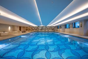 福州福州融侨水乡皇冠假日酒店的蓝色楼层的一座建筑中的游泳池