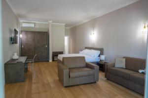 蒂沃利La Tenuta di Rocca Bruna Country Resort的酒店客房配有床、沙发和椅子
