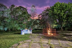 马迪凯里库格马迪凯里马辛德拉俱乐部酒店的火坑,在田野里,有一组桌子