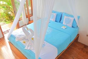 庞岸达兰Lagoona Beach Bungalows - Eco Stay的一间卧室配有一张带秋千的床