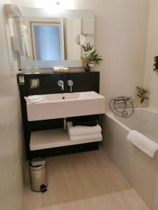 巴登戈维尼斯之家酒店的浴室配有盥洗盆和浴缸。