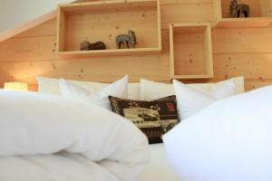 塞尔瓦迪加尔代纳山谷Hotel Valpudra的卧室配有床上的白色枕头