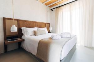 普拉迪斯亚罗斯米科诺斯布兰科酒店的卧室配有带毛巾的大型白色床