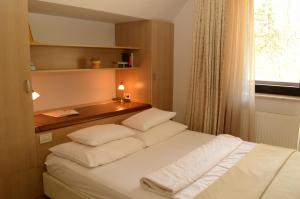 博希尼Vila Park B&B - Adults Only的卧室配有带白色枕头的床和窗户。