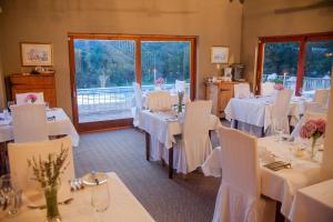 HekpoortSteynshoop Mountain Lodge (Hotel)的用餐室配有白色的桌子和白色的椅子
