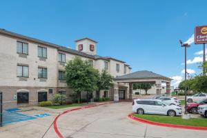 韦瑟福德Clarion Inn & Suites Weatherford South的停车场内有车辆的旅馆