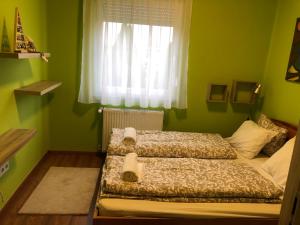 迈泽克韦什德Galéria deluxe apartman的绿色卧室设有两张床,配有窗户