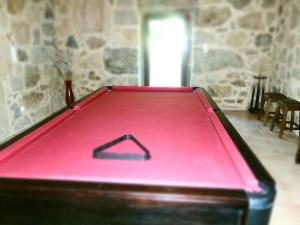 帕雷迪什迪科拉金塔达甘德拉乡村民宿的石墙房间内的红色台球桌