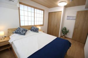 东京Uhome Suido Apartment SD的卧室配有带蓝色枕头的大型白色床